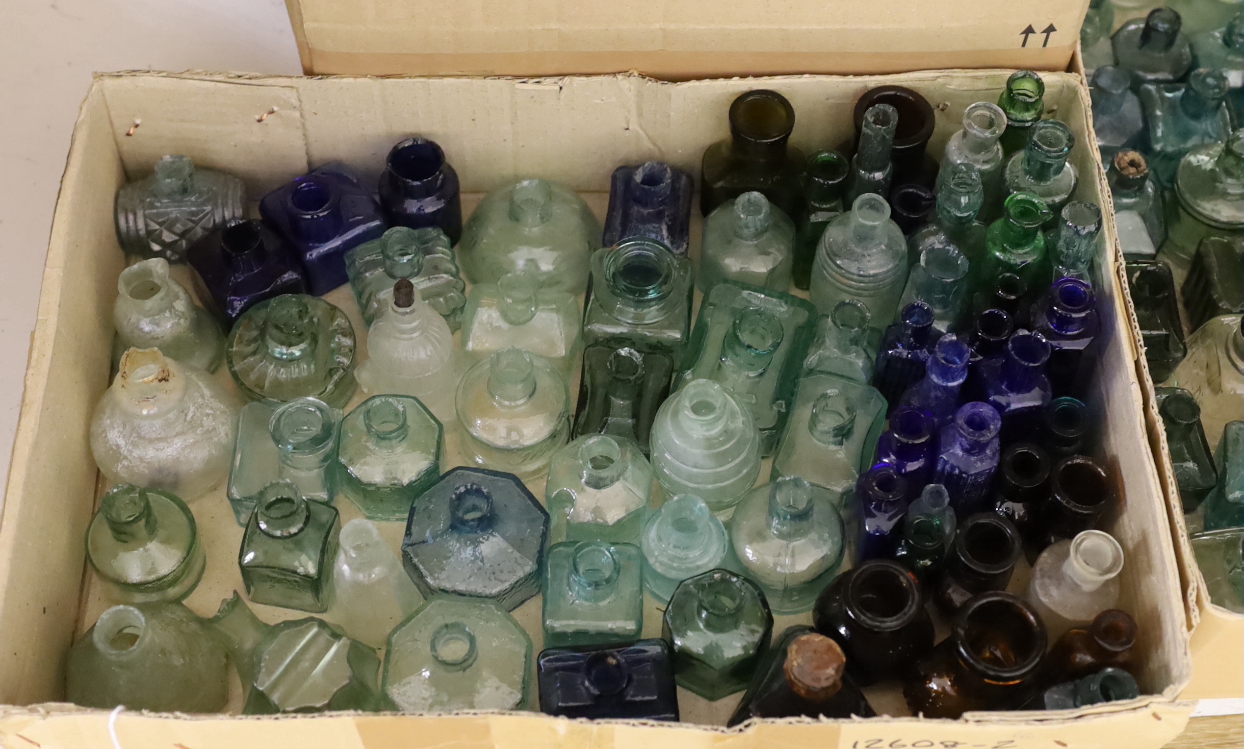 A collection of late 19th/early 20th century glass ink bottles, drink bottles and sauce bottles, brand names and advertising moulded into the glass on a number of examples, many ink bottles with pen rests moulded into th